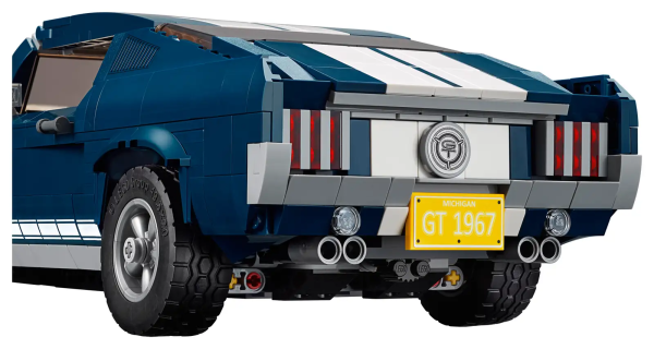 Discover the magic of an iconic 1960s American muscle car with the LEGO® Creator Ford Mustang, featuring dark-blue bodywork with white racing stripes, bonnet scoop, printed mustang grille badge, GT emblems and 5-spoke rims with road-gripping tires. Developed with input from Ford, this authentic replica comes with optional add-ons for customization, including a selection of license plates, supercharger, rear ducktail spoiler, beefy exhaust pipes, front chin spoiler and a nitrous oxide tank. You can even adjust the lift of the rear axle for an extra-mean look! Remove the roof panel or open the doors and you have access to the detailed interior with handsome seats, radio, working steering and a mid-console gearshift. Store items in the trunk or lift the hood to reveal a detailed big block 390 V8 engine with battery, hoses and air filter detailing. This advanced building set has been designed to provide a challenging and rewarding building experience full of nostalgia and makes a great centerpiece for the home or office. Authentic replica of a 1960s Ford Mustang featuring dark-blue bodywork with white racing stripes, air scoop, 5-spoke rims with road-gripping tires, and a selection customization add-ons. Open the doors or remove the roof panel to access the detailed interior with handsome seats, radio, mid-console gearshift and working steering. Open the trunk to store items and lift the hood to reveal a detailed Ford Mustang V8 engine with battery, hoses and air filter. Also includes a printed mustang grille badge and 2 GT emblems. Customize the Ford Mustang with the included supercharger, rear ducktail spoiler, beefy exhaust pipes, front chin spoiler and a nitrous oxide tank. Choose from a selection of license plates. Lift the hood to check out the realistic engine detailing. Adjust the lift of the rear axle for a real mean look! New-for-March-2019 special elements include 5-spoke rims, 2x8 brick with bow, 1x3 mustang logo tile, 2x4 bow with ‘GT’ Emblem. Measures over 3” (10cm) high, 13” (34cm) long and 5” (14cm) wide.