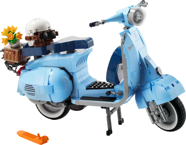 Dive into a mindful building project packed with style with this LEGO® Vespa 125 model kit for adults. Inspired by the classic 1960s Vespa Piaggio, it comes in pastel blue – a very rare LEGO color that’s sure to appeal to building fans. To celebrate Vespa’s 75th anniversary, the LEGO designers have worked closely with the lifestyle brand to recreate this stunning model in an immersive build, especially for adults. Beautiful details. Authentic features Like the original, this buildable model Vespa features a front wheel mounted on one side, 2 seats, a removable engine cover with a brick-built engine beneath, a functioning kickstand, plus working steering. Finishing touches include the Vespa logo, a classic 1960s Italian license plate, a spare wheel, a helmet, plus an accessories basket including a flower bouquet on the back. Welcome to your zone Build creativity. Build concentration. Build your dream vehicle collection with exclusive, authentic model vehicles, made specifically for adults. Assemble your own LEGO® Vespa 125 – Build a detailed displayable model of an Italian icon with this building set (10298) for adults Inspired by the original – This brick-built Vespa features a front wheel mounted on one side, 2 seats, a removable engine cover with a brick-built engine underneath, and working steering Extra details – Finishing touches include the Vespa logo, a classic 1960s Italian license plate, a spare wheel, helmet and an accessories basket with flower bouquet Designed for Vespa fans – To celebrate Vespa’s 75th anniversary, the LEGO® designers have worked with the lifestyle brand to create a model to appeal to lovers of Italian culture A rare color – Presented in pastel blue, one of the Vespa’s original production colors and an extremely rare LEGO® color designed to appeal to LEGO fans Celebrate La Dolce Vita – With its functioning kickstand, this model can be placed on display in the home or office to create your own tribute to Vespa Dimensions – This collectible display model measures over over 8.5 in. (22 cm) high, 13.5 in. (35 cm) long and 4.5 in. (12 cm) wide A project for adults – This LEGO® set is part of a range of building sets designed for adult building fans and makes a gift idea for Vespa fans Quality materials – LEGO® building bricks are manufactured from high-quality materials. They’re consistent, compatible and connect and pull apart easily every time: it’s been that way since 1958 Safety ensured – With LEGO® pieces, safety and quality come first. That’s why they’re rigorously tested so you can be sure that this Vespa model kit is robust