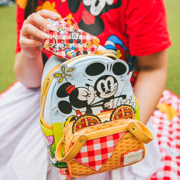 Life’s a picnic when you’re with your pals! Spend a sunny day in the countryside with the Loungefly Mickey and Friends Picnic Mini Backpack. On the front, a woven picnic basket takes shape on the bag’s zipper pocket. Look inside the basket to find a Mickey-shaped pie, which doubles as a strawberry-scented coin bag! Minnie and Mickey appear up above while Donald, Daisy, and Goofy join the fun on the bag’s side pockets. On the back, gingham shoulder straps accompany Pluto as he sizes up a tasty feast. This mini backpack makes a stylish addition to any outing and has plenty of room to pack your picnic essentials. The Loungefly Mickey and Friends Picnic Mini Backpack is made of vegan leather (polyurethane). Bag has adjustable shoulder straps, removeable coin bag (polyurethane), and shiny gold hardware. Additional features include applique, debossed, scented, and printed details. Take note of the coordinating inside lining. This backpack is an officially licensed Disney product. Backpack dimensions: 9”W x 10.5”H x 4.5”D