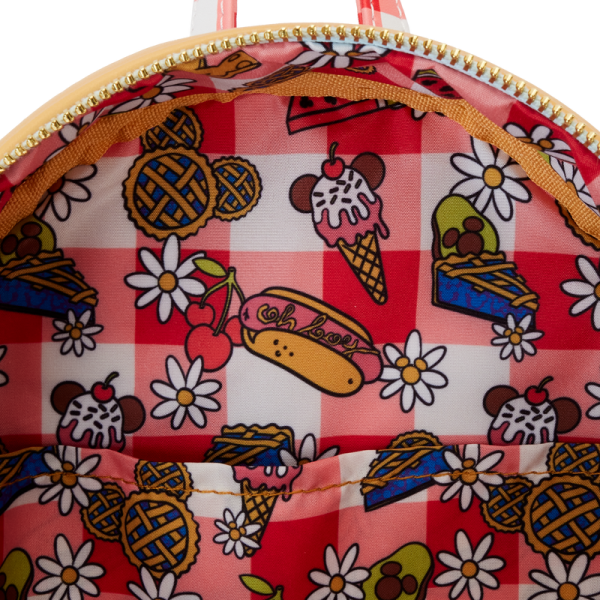 Life’s a picnic when you’re with your pals! Spend a sunny day in the countryside with the Loungefly Mickey and Friends Picnic Mini Backpack. On the front, a woven picnic basket takes shape on the bag’s zipper pocket. Look inside the basket to find a Mickey-shaped pie, which doubles as a strawberry-scented coin bag! Minnie and Mickey appear up above while Donald, Daisy, and Goofy join the fun on the bag’s side pockets. On the back, gingham shoulder straps accompany Pluto as he sizes up a tasty feast. This mini backpack makes a stylish addition to any outing and has plenty of room to pack your picnic essentials. The Loungefly Mickey and Friends Picnic Mini Backpack is made of vegan leather (polyurethane). Bag has adjustable shoulder straps, removeable coin bag (polyurethane), and shiny gold hardware. Additional features include applique, debossed, scented, and printed details. Take note of the coordinating inside lining. This backpack is an officially licensed Disney product. Backpack dimensions: 9”W x 10.5”H x 4.5”D