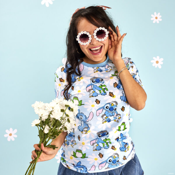 New beginnings are in bloom! Embrace a season of fresh starts with the Loungefly Lilo & Stitch Springtime Stitch Unisex Tee. This comfortable tee shirt features an all-over print of the loveable alien as he makes flower crowns for all his friends. White daisies cover a blue background, where Stitch plays with some frogs and ducklings. Look closely and you may find a butterfly perched on Stitch’s nose! This cute and cozy tee makes an adorable addition to any outfit and will keep you looking stylish on your next outing. The Loungefly Lilo & Stitch Springtime Stitch Unisex Tee is made of super soft 100% cotton jersey material. Please note: Patterns will vary with all-over print styles. Not every piece will look identical nor will every piece be an exact match as to what is pictured online. This tee is an officially licensed Disney product. Comes in unisex sizes S through 3X. Sizing is very specific, so please consult the size chart before purchasing.