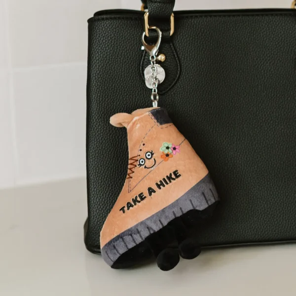 Talk to the hand? More like, take a hike! This bag charm is not afraid to give you the boot! Her sassy smile and expressive eye are just *chef’s kiss.* She’d be a fun addition to any purse, wallet, or backpack.