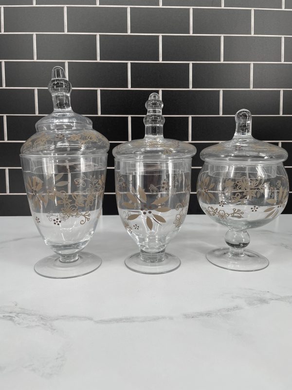 The Temp-tations Classic Set of 3 Glass Kitchen Apothecary Jars in Taupe offers a stylish and practical solution for organizing your kitchen. These elegant jars are made from durable glass, providing a clear view of their contents while adding a touch of sophistication to your countertop or pantry. The taupe color gives them a modern, neutral look that complements various décor styles. Each jar features an airtight lid to keep contents fresh and protected from moisture. Perfect for storing ingredients like sugar, flour, coffee, or even small kitchen tools, this set brings both functionality and charm to your culinary space.