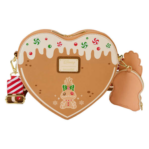 Crash the cookie swap with a sweet new accessory. Disney’s Stitch, Angel, and Scrump are fresh and fun gingerbread-themed features of this heart-shaped crossbody bag. And, this accessory carries a gingerbread scent! You’ll find plenty of festive icing and delightful embroidered and printed candies as well. The detachable coin purse of Scrump adds a festive option for securing smaller items on your journeys. Stash this crossbody bag with everything you need to spend the day enjoying the season and savoring favorite memories. Features: Vegan leather (polyurethane) Adjustable, detachable strap with gingerbread motif Zippered main compartment Detachable coin purse Gold-colored metal hardware Applique, scented, embroidered, 3D bow, debossed, and printed details Coordinating inside lining Dimensions: 9”W x 8.3”H x 3”D This bag is an officially licensed Disney product.