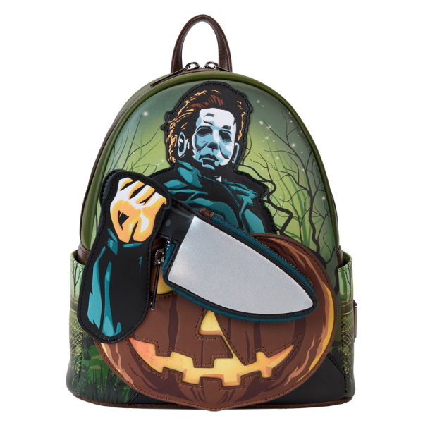 Crash the haunted hayride party looking sharp. Bring along our Halloween Mini Backpack. This accessory features Michael Myers in eerie applique detail, his form rising up over the front pocket. The front pocket is shaped like a jack-o’-lantern, and Michael Myers brandishes a knife with a reflective metallic vegan leather “blade.” This applique knife doubles as a removable coin bag for storing smaller items on your journeys. In the dark, the jack-o’-lantern’s eyes and mouth glow! The gleaming knife makes an encore appearance as a print on the back. Pack your daily essentials and stalk your favorite haunts in style. Features: Vegan leather (polyurethane) in dark green with brown trim Padded, adjustable shoulder straps in dark brown Side pockets with artwork of dark branches, grass, and barbed wire Zippered main compartment for securing items Zippered front compartment for storing smaller items Removable coin purse Gunmetal-colored hardware Applique, glow-in-the-dark, reflective metallic vegan leather, and printed details Coordinating inside lining Dimensions: 9”W x 10.5”H x 4.5”D This backpack is an officially licensed Compass International Pictures product.