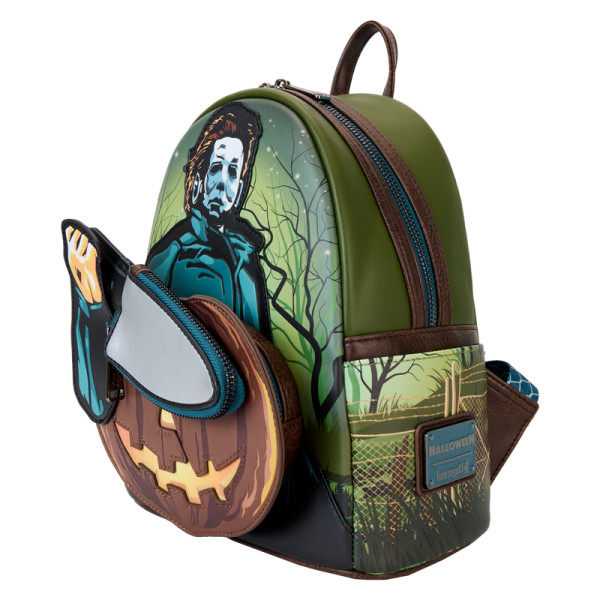 Crash the haunted hayride party looking sharp. Bring along our Halloween Mini Backpack. This accessory features Michael Myers in eerie applique detail, his form rising up over the front pocket. The front pocket is shaped like a jack-o’-lantern, and Michael Myers brandishes a knife with a reflective metallic vegan leather “blade.” This applique knife doubles as a removable coin bag for storing smaller items on your journeys. In the dark, the jack-o’-lantern’s eyes and mouth glow! The gleaming knife makes an encore appearance as a print on the back. Pack your daily essentials and stalk your favorite haunts in style. Features: Vegan leather (polyurethane) in dark green with brown trim Padded, adjustable shoulder straps in dark brown Side pockets with artwork of dark branches, grass, and barbed wire Zippered main compartment for securing items Zippered front compartment for storing smaller items Removable coin purse Gunmetal-colored hardware Applique, glow-in-the-dark, reflective metallic vegan leather, and printed details Coordinating inside lining Dimensions: 9”W x 10.5”H x 4.5”D This backpack is an officially licensed Compass International Pictures product.