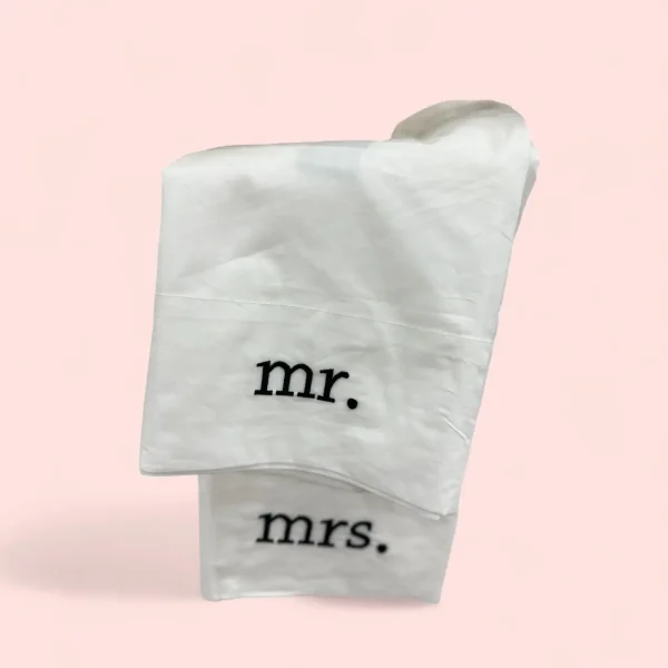 The Concierge Collection Mr. & Mrs. 2-Piece Set in King White is a charming addition to your bedroom that celebrates the union of marriage. This set includes two king-sized pillowcases, each embroidered with "Mr." and "Mrs." in elegant script, adding a personalized and romantic touch to your bedding. Made from soft, high-quality fabric, these pillowcases are designed to provide comfort while enhancing the aesthetic of your bedroom décor with their crisp white color. Perfect for newlyweds, anniversaries, or anyone looking to add a touch of love and luxury to their sleep space.