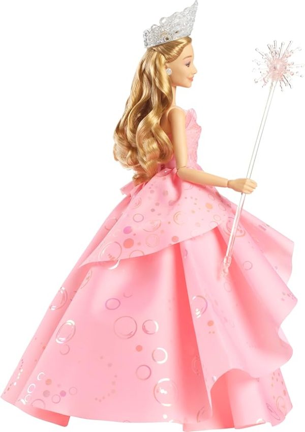 Inspired by Universal Pictures' Wicked, the deluxe Glinda doll captures her signature look from the musical film! Embellished bold, statement earrings, Glinda wears her voluminous, ruffled pink ballgown with iridescent foil bubble details that complete her magical look! The Good Witch doll accents her outfit with her wand and tiara! With true-to-movie looks and long blonde hair perfectly styled in curls, Glinda doll charms with a true-to-movie look! Clip Glinda doll onto the doll stand and create dramatic poses with 11 points of articulation! Highlighting the beauty of sisterhood and friendship, Wicked dolls make an inspiring gift for kids to play out their biggest dreams! Fans can collect their favorite Wicked characters to recreate scenes and make up their own storylines and adventures.