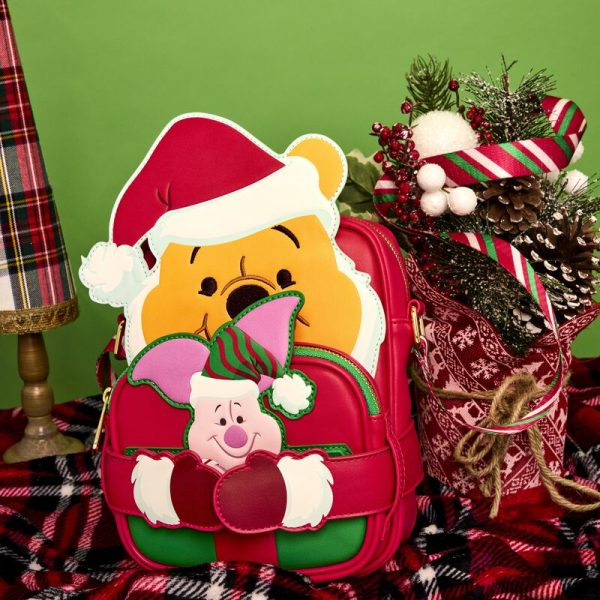 Hang the lights and pass the honey! Our Disney’s Winnie the Pooh Crossbuddies™ bag is a festively sweet way to celebrate the holidays in style. Winnie the Pooh is all decked out in a Santa hat and beard. His applique hands hug a detachable, reversible coin bag, which you can fill with a sweet treat or two. On one side, you’ll find an applique print of Disney’s Piglet, and on the other side, you’ll discover a printed applique of a beautifully wrapped honey pot gift. Piglet even makes an encore appearance as a print, inside a jar of honey. Make the season even sweeter with this fun accessory. Features: Vegan leather (polyurethane) Adjustable shoulder straps with a candy-cane striped print Detachable, reversible coin purse Gold-colored metal hardware Applique and printed details Coordinating inside lining Dimensions: 6.25”W x 8.25”H x 2.25”D