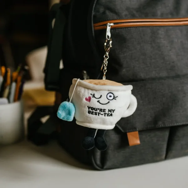 This Bag Charm might be little, but she's got a big cup of pipping hot tea! Her favorite thing is sharing some hot goss with you, her best-tea! Her sweet smile, dangling legs, and 3D accents make her so brew-tea-ful. An added claw clip makes her the cutest accessory. Just clip her onto any purse, bag, or backpack. She's the perfect gift for your bestie with the best tea! This plush is ideal for children, collectors, or anyone who loves cozy and fun decor.