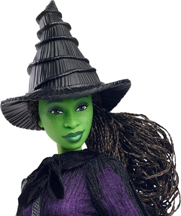 Inspired by Universal Pictures’ Wicked, this deluxe Elphaba doll captures her magical look from the musical film! With a cape draping over a sheer black dress and black boots, Elphaba can create a dramatic exit! Her iconic witch hat, broom, and satchel add the finishing touches to the signature look! With green skin and black braided hair, Elphaba doll charms with a true-to-movie look! Clip Elphaba doll onto the doll stand and create dramatic poses with 11 points of articulation! Highlighting the beauty of sisterhood and friendship, Wicked dolls make an inspiring gift for kids to play out their biggest dreams! Fans can collect their favorite characters to recreate scenes and make up their own storylines and adventures.