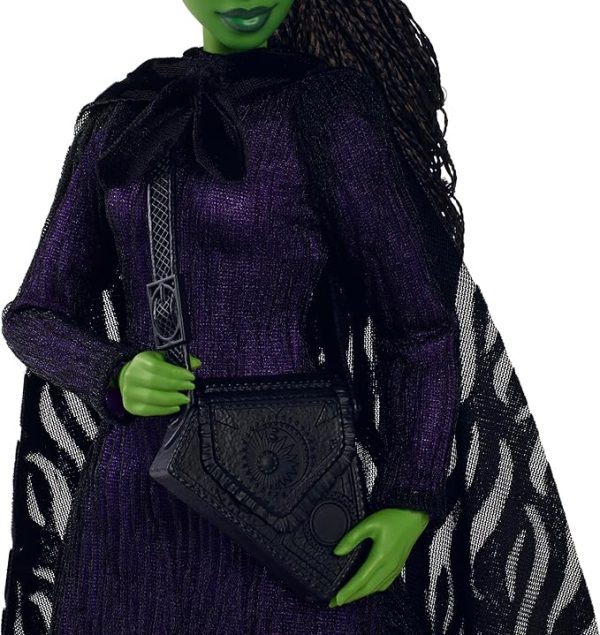 Inspired by Universal Pictures’ Wicked, this deluxe Elphaba doll captures her magical look from the musical film! With a cape draping over a sheer black dress and black boots, Elphaba can create a dramatic exit! Her iconic witch hat, broom, and satchel add the finishing touches to the signature look! With green skin and black braided hair, Elphaba doll charms with a true-to-movie look! Clip Elphaba doll onto the doll stand and create dramatic poses with 11 points of articulation! Highlighting the beauty of sisterhood and friendship, Wicked dolls make an inspiring gift for kids to play out their biggest dreams! Fans can collect their favorite characters to recreate scenes and make up their own storylines and adventures.